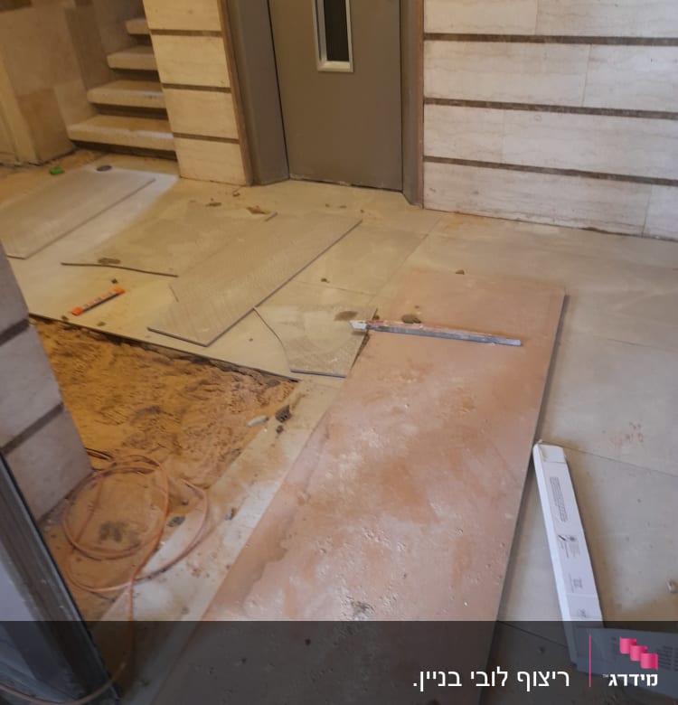 חומרים וכלים לשיפוץ ליד דלת, כולל לוחות וחוטים